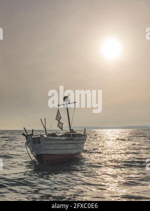 Sonnenuntergang über einmundem Fischerboot am Ufer der Ostsee Stockfoto