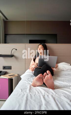 Nachdenkliche Unternehmerin mit Laptop im Hotel Stockfoto