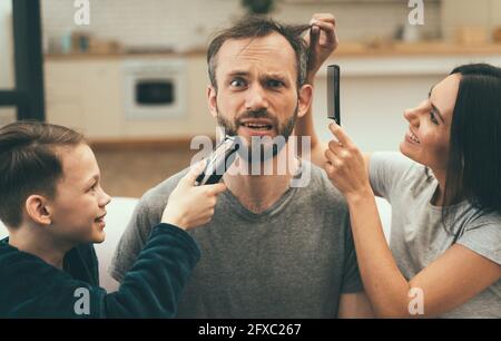 Besorgt Mann immer Frisur mit Familie zu Hause Stockfoto