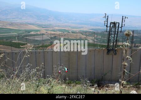 Die Grenzmauer zwischen Südlibanon und Israel am 26. Mai 2021 in Odaisseh, einem Dorf an der sogenannten „Blauen Linie“. In den vergangenen Wochen haben libanesische Demonstranten die Mauer geklettert und Flaggen des Libanon und der Hisbollah darauf gesetzt. (Foto: Elisa Gestri/Sipa USA) Quelle: SIPA USA/Alamy Live News Stockfoto