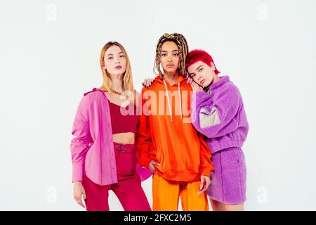 Stilvolle Freundinnen stehen vor weißem Hintergrund Stockfoto