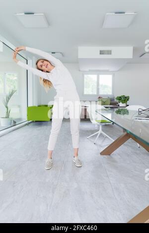 Weibliche professionelle Stretching-Übung am Konferenztisch im Büro Stockfoto