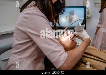 Weibliche Zahnärztin, die den Patienten in der Klinik überprüft Stockfoto