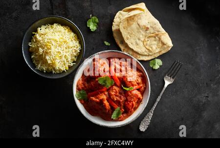 Studioaufnahme einer Schüssel mit Hühnchen-Tikka, einer Schüssel mit Basmati-Reis und Naan-Brot Stockfoto