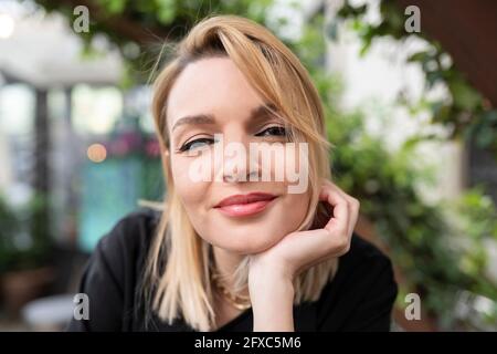 Lächelnde Frau mit Hand am Kinn Stockfoto