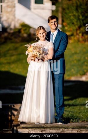 Frisch verheiratetes Paar mit Blumenstrauß Stockfoto