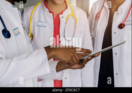 Arzt mit digitalem Tablet von weiblichen Kollegen im Krankenhaus Stockfoto