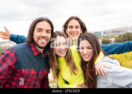 Glückliche männliche und weibliche Freunde stehen unter dem Himmel Stockfoto