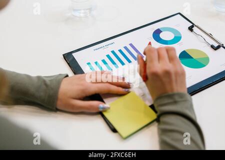 Junge Geschäftsfrau, die am Schreibtisch im Büro an einem Finanzbericht arbeitet Stockfoto