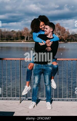 Junger Mann Huckepack Frau auf dem Fußweg Stockfoto
