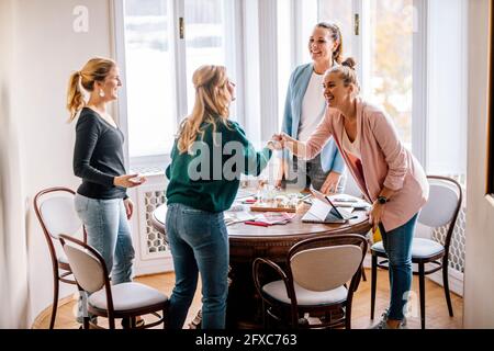 Lächelnde weibliche Profis begrüßen sich gegenseitig Stockfoto