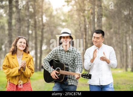 Junge männliche und weibliche Freunde genießen Party im Wald Stockfoto