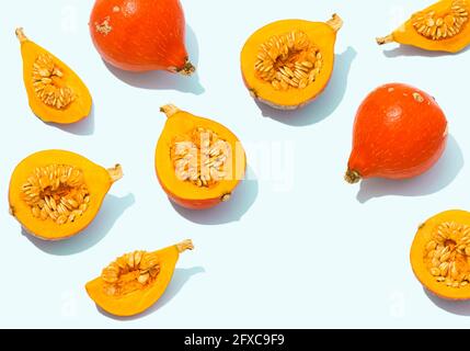 Studioaufnahme von ganzen und halbierten roten kuri-Squashes Stockfoto