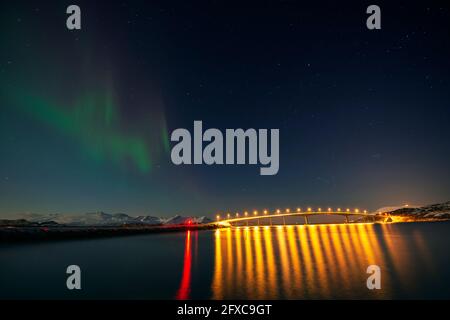 Norwegen, Tromso, Sommaroy, Aurora Borealis über beleuchtete Brücke Stockfoto