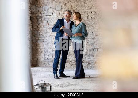 Architekten und Architektinnen diskutieren auf der Baustelle Stockfoto