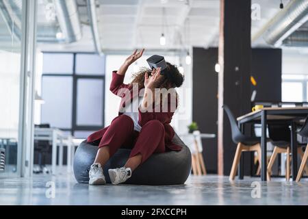 Geschäftsfrau, gestikulieren mit virtual-Reality-Simulator im Büro Stockfoto