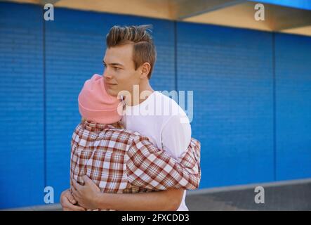 Junge Frau mit Strickmütze umarmt Mann Stockfoto