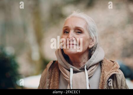 Porträt von lächelnden grauhaarigen älteren reifen Frau im Freien Stockfoto