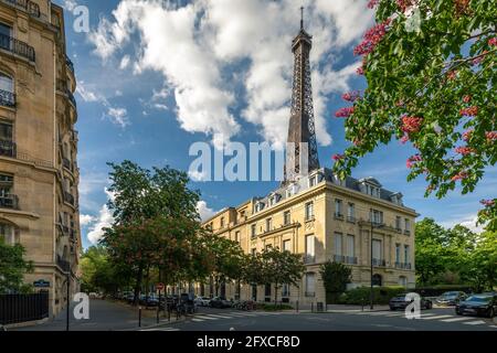 Paris, Frankreich - 10. Mai 2021: Gemütliche Straße mit Blick auf den Eiffelturm in Paris. Der Eiffelturm ist eines der berühmtesten Wahrzeichen der Stadt Stockfoto