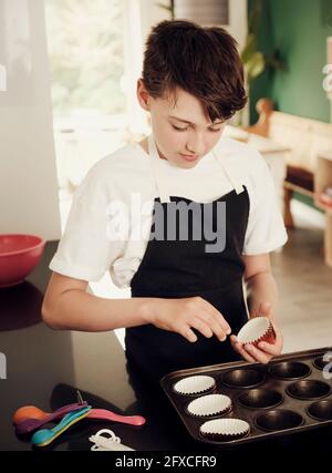 Junge bereitet Muffin-Tablett in der Küche zu Hause Stockfoto