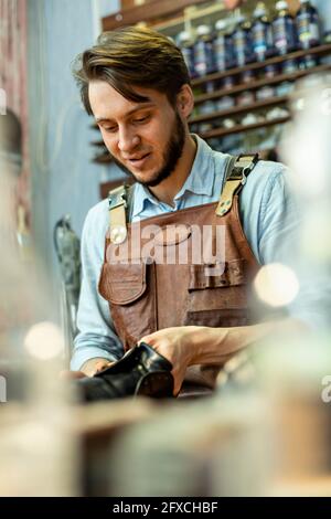 Männlicher Schuhmacher repariert Schuhe in der Werkstatt Stockfoto