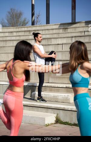 Männliche und weibliche Freunde machen Stretching-Übung Stockfoto