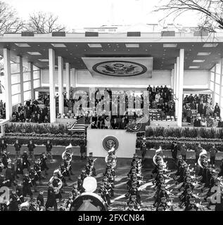 Eröffnungsparade für Präsident John F. Kennedy entlang der Pennsylvania Avenue, Washington, D.C., Armored United States Army Vehicles, Bands und Marschers passieren die Überprüfung Stand, wo Präsident Kennedy, First Lady Jacqueline Kennedy, der Vater des Präsidenten Joseph P. Kennedy, Sr., Vice President Lyndon B. Johnson, Lady Bird Johnson und andere beobachten. Stockfoto