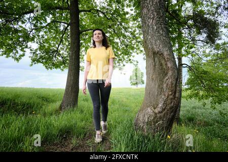 Frau geht an einem sonnigen Tag einen Pfad entlang. Stockfoto