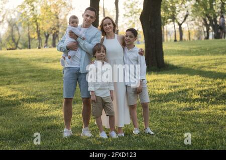 Glückliche harmonische Familie mit drei Kindern im Freien. Familienportrait im Park. Stockfoto