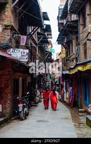Ein nepalesisches Paar, das durch die Straßenmarktstraße in Bhaktapur, Nepal, läuft Stockfoto