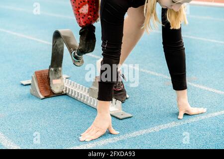 Crop Sportlerin mit Behinderung in der Crouch-Startposition stehen Stockfoto