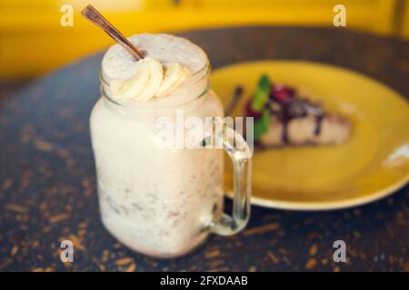 Smoothie und Käsekuchen mit gelbem Hintergrund. Konzept von gesund Stockfoto