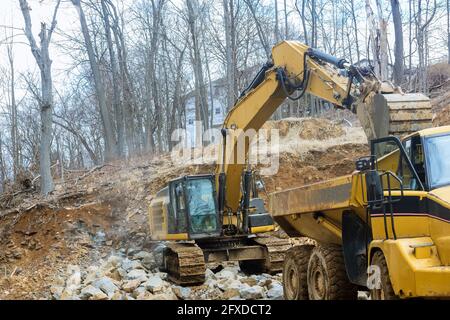 Bagger arbeiten mit einem Steintraktor Lasten Lastwagen Steintransporte Mit Stein Stockfoto