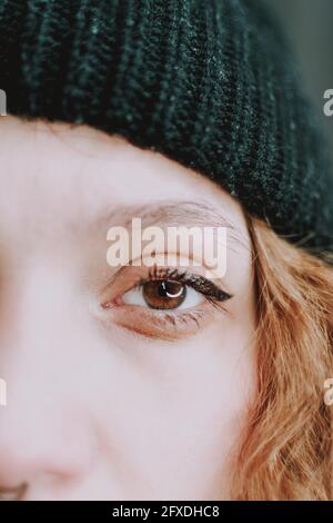 Vertikale Aufnahme der Hälfte des weiblichen Gesichts mit einem Auge und blonden Haaren Stockfoto