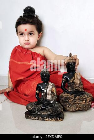 Beawar, Indien. Mai 2021. Viele Familien mit Glauben an den Buddhismus feierten Buddha Purnima in Indien. In einer Familie, 2-jährige Vaayu Sharma gekleidet als buddhistischer Mönch mit Idolen von Lord Buddha anlässlich von Buddha Purnima in Beawar. Buddha Purnima, das größte religiöse Fest der buddhistischen Gemeinschaft, markiert das Aufkommen, Erlangen des Nirvanas oder die Erleuchtung und den Aufbruch von Lord Gautama Buddha. (Foto: Sumit Saleswat/Pacific Press) Quelle: Pacific Press Media Production Corp./Alamy Live News Stockfoto