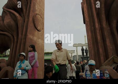 Menschen, die sich in der Nähe des Heroes Monument (10. November Monument) und der Soekarno-Hatta Statue in Surabaya, Ost-Java, Indonesien, Freizeit nehmen. Stockfoto