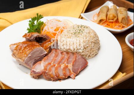 Schweinebauch, brauner Reis und Frühlingsrollen in einem koreanischen Restaurant. Stockfoto