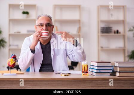 Alte Zahnarztlehrerin sitzt im Klassenzimmer Stockfoto