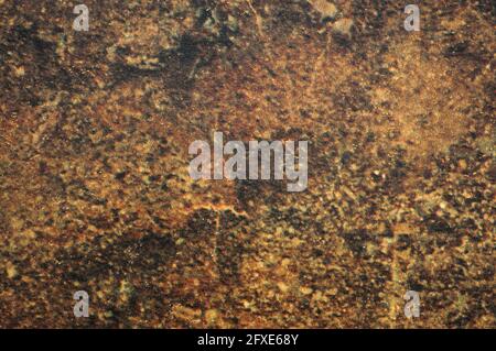 Dunkelbrauner Granit, flache polierte Oberfläche aus Naturstein in Nahaufnahme. Hintergrund, Muster, Textur. Stockfoto