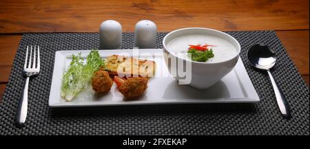 Creme der Pilzsuppe in einer weißen Schüssel mit angeordnet Geröstetes Brot und frischer grüner Gemüse-Salat als Beilage Auf einem weißen, grauen Servierbrett angeordnet Stockfoto