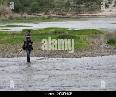 Del Rio, USA. Mai 2021. Alberto und sein Sohn Andres überqueren den Rio Grande von Mexiko aus an einem flachen Punkt und betreten kurze Zeit später amerikanischen Boden in der US-Grenzstadt. (To dpa: 'Bidens Problemzone') Quelle: Lena Klimkeit/dpa/Alamy Live News Stockfoto