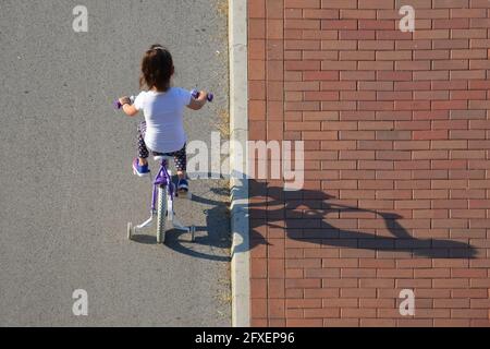 NOVI SAD, SERBIEN - 26. Mai 2018: Novi Sad, Serbien - 26. Mai 2018.: Mädchen auf dem Fahrrad Draufsicht Stockfoto