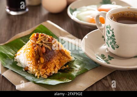 Gemeinsames orientalisches Frühstück in Malaysia, bestehend aus Kaffee, Nasi Lemak, Toastbrot und halbgekochtem Ei Stockfoto