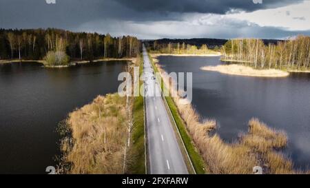 Eine Luftaufnahme einer schmalen geraden Straße durch die see bei Sonnenuntergang Stockfoto