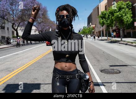 Los Angeles, CA, USA. Mai 2021. Eine Frau steht einen Moment lang mit erhobener Faust auf einem marsch, der zu Ehren von George Floyd anlässlich des einjährigen Jahrestages seines Mordes durch den ehemaligen Polizeibeamten Derek Chauvin organisiert wurde. Quelle: Raquel Natalicchio/ZUMA Wire/Alamy Live News Stockfoto