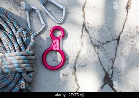 Gewickeltes Kletterseil und Stahlkarabiner. Bergkletterausrüstung: Karabiner, Gurtzeug, Bremsen, Schnellziehungen, Selbstversicherung, Gerät 8. Auf einem Stockfoto