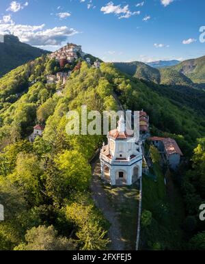 Luftaufnahme von Santa Maria del Monte und den Kapellen des heiligen Weges bei einem Frühlingsuntergang. Sacro Monte di Varese, Varese, Lombardei, Italien. Stockfoto