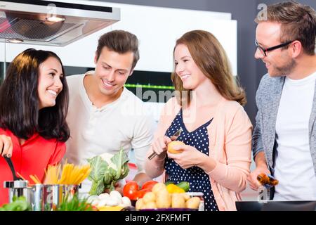 Freunde kochen Spaghetti und Fleisch in der heimischen Küche Stockfoto