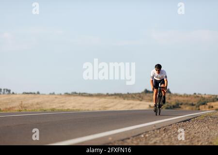 Ausdauernder Mann, der morgens beim Radfahren praktiziert Stockfoto