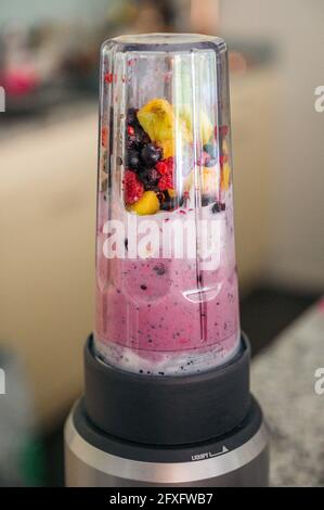 Smoothie-Schüssel mit Mango und Beeren im Mixer Stockfoto